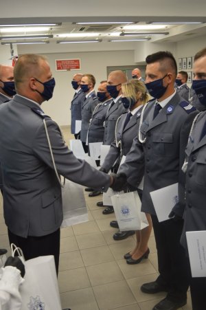 Komendant Powiatowy Policji młodszy inspektor Grzegorz Wyskiel wręczający nagrodę funkcjonariuszowi