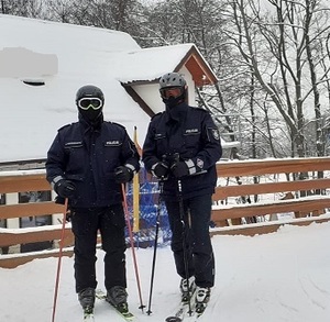 policjanci w patrolu narciarskim stoją obok siebie na nogach mają założone narty