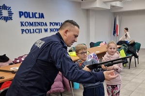 policjant prezentuje broń dziecku