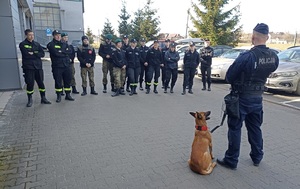 policjant z psem służbowym rozmawia z uczniami
