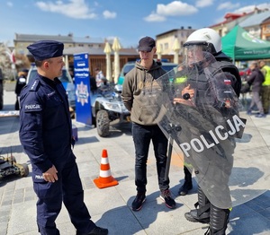 policjant rozmawia z uczniami, jeden z nich ubrany w policyjny PZ