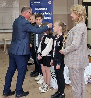 Burmistrz zakłada medal dziewczynce