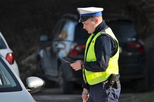 policjant ruchu drogowego w białej czapce i kamizelce odblaskowej