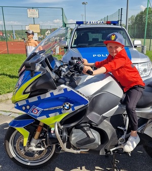 chłopczyk siedzi na motocyklu policyjnym