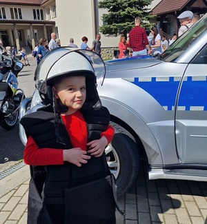 chłopczyk w kamizelce i kasku policyjnym