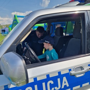 policjant pokazuje chłopcu radiowóz