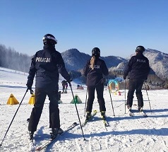 policjanci na nartach stoją na stoku