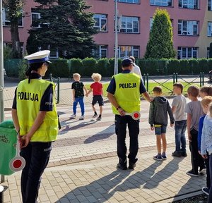 policjanci uczą dzieci jak bezpiecznie przechodzić przez jezdnię