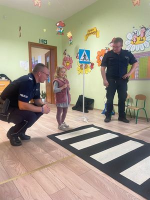 policjanci tłumaczą dziecku jak poruszać się po pasach