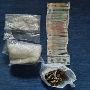 narkotyki zapakowane w foliowe worki oraz pieniądze ułożone na blacie