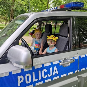 dzieci siedzą w radiowozie