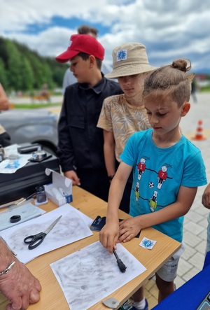 chłopiec pędzelkiem ujawnia odciski dłoni