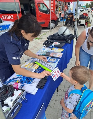 policjantka przekazuje ulotkę dziecku