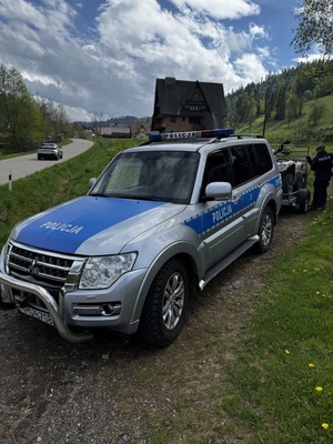 Radiowóz policyjny z przypieta przyczepka na której znajduej sie quad