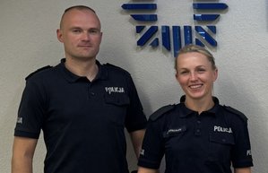 Dwójka policjantów na tle nazwy komendy