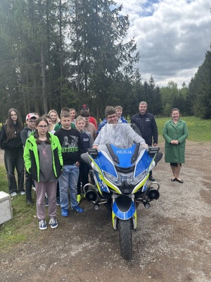 Dzieci stojące obok motocykla słuzbowego policji