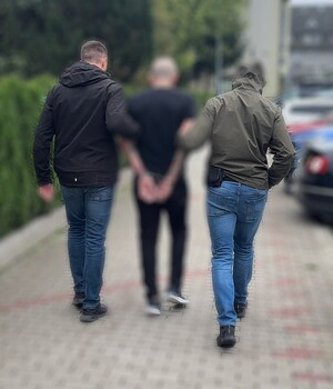 Poszukiwany mezczyzne w towarzystwie dwócn nieumundurowanych policjantów