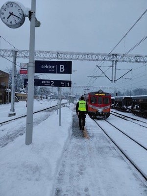 Policjant na peronie w tle pociąg