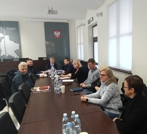 Męzczyzni i kobiety siedzący przy stole