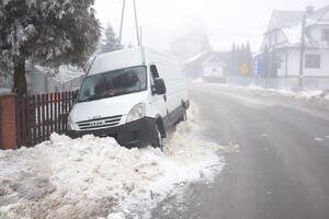 biały bus stojący w sniegu oparty
