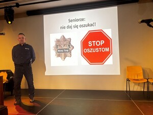 Policjant w tle wyświetlany slajd stop oszustom