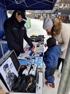 Policjantka rozamwia z dzieckime oraz jego rodzicem