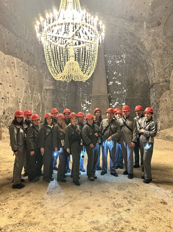 zdjecie grupowe osób przebranych w kombinezony z kaskami na głowach