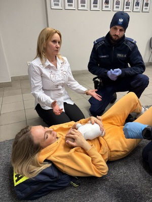 kobieta w białej bluzce obok policjant