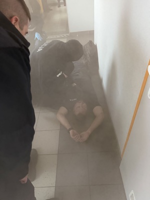 zadymiony korytarz na podlodze lezacy mezczzyna