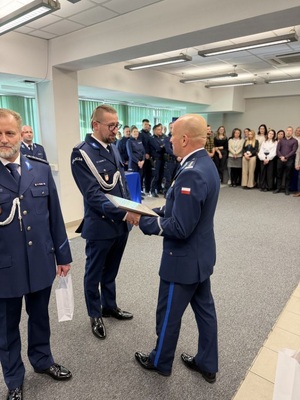 policjant przekazaujacy drugiemu grawer