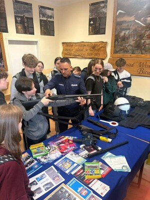 POLICJANT PREZENTUJACY STRZELBE DZIECIOM