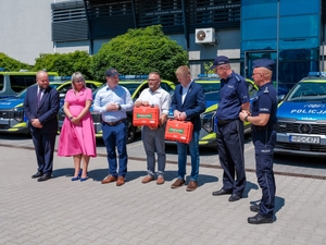 mężczyźni z czerwonymi walizkami i policjanci