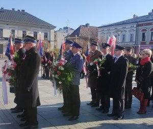 uczestnicy stoją z kwiatami